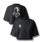 A black cropped t-shirt shown from both front and back. The front features a small white glitch-style graphic on the left chest, while the back displays a larger white glitch-art graphic of a face with the text 'GIRL I EXIST' and 'I'M NOT A HUMAN'.
