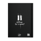 A black hardcover notebook with a white graphic of two vertical bars and the text 'offline for a moment' on the front cover, with 'CITY+ exist' branding at the bottom.