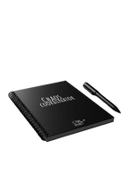 Notebook titled 'Chaos Coordinator' with a pen on a dark surface, illuminated by colorful lights in the background.