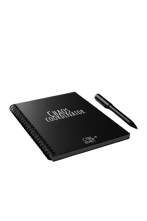 Notebook titled 'Chaos Coordinator' with a pen on a dark surface, illuminated by colorful lights in the background.