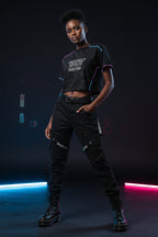 Person wearing a black t-shirt with 'BREWTUS' logo and denim shorts on a white background